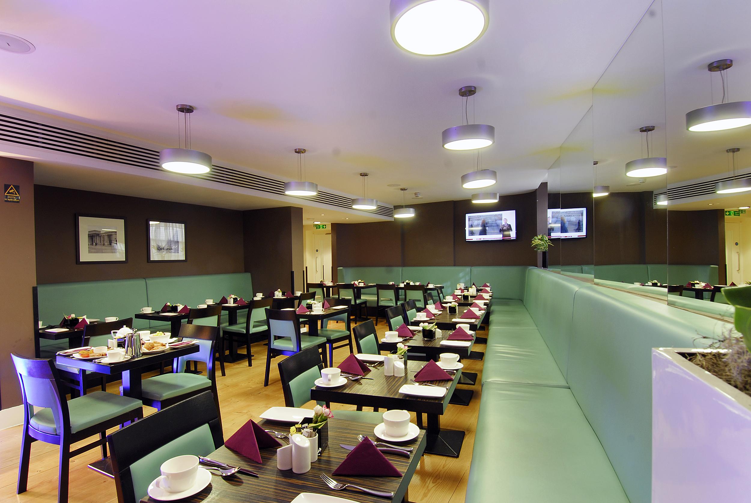 Inhabit Queen'S Gardens, A Member Of Design Hotels London Eksteriør billede The photo depicts a restaurant interior with a modern and stylish design. The space features an arrangement of tables and chairs, each set with plates, cutlery, and folded napkins in a triangular shape, indicating that it is prepared for dining. Ther